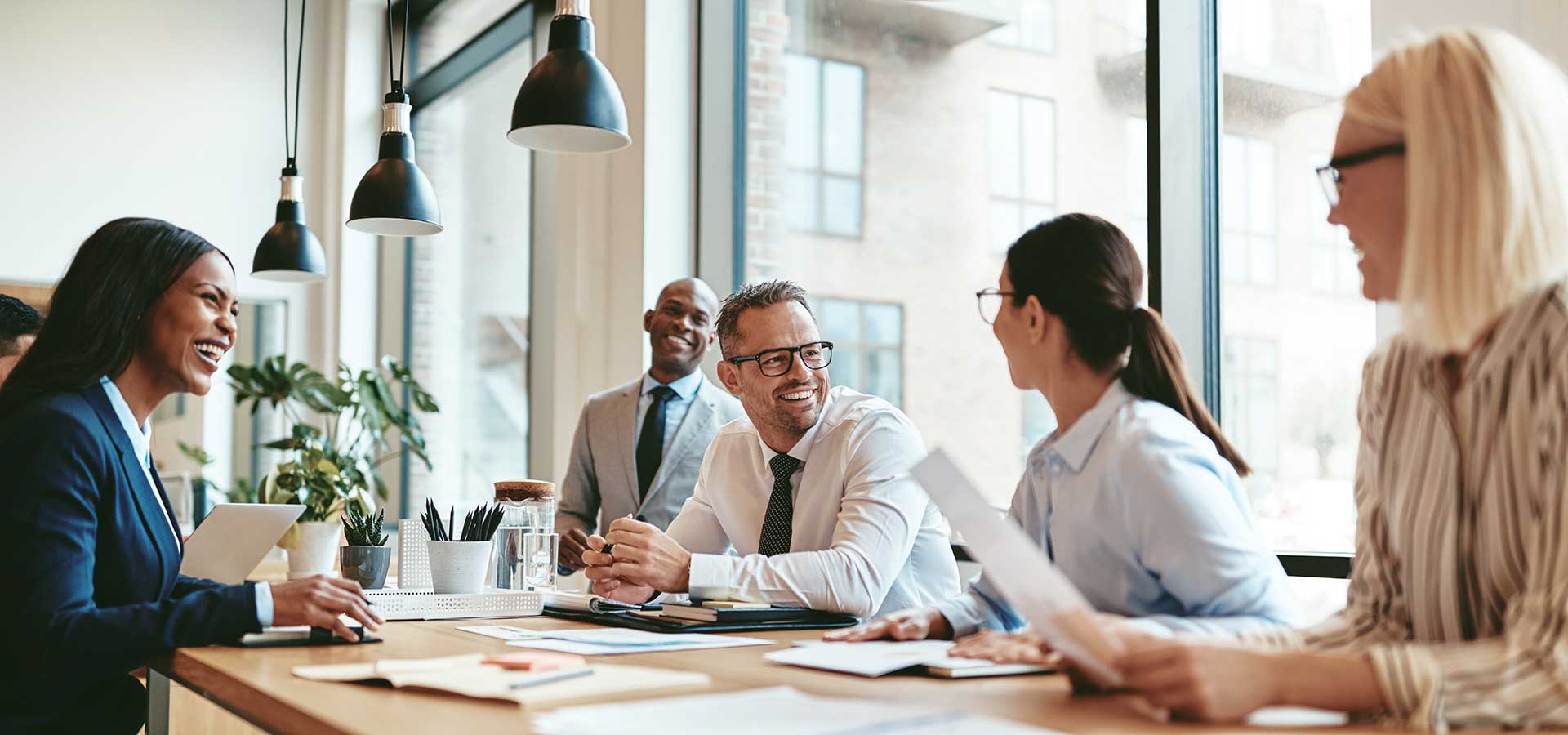 A team of business individuals seated at a table, actively participating in a meeting or brainstorming session.