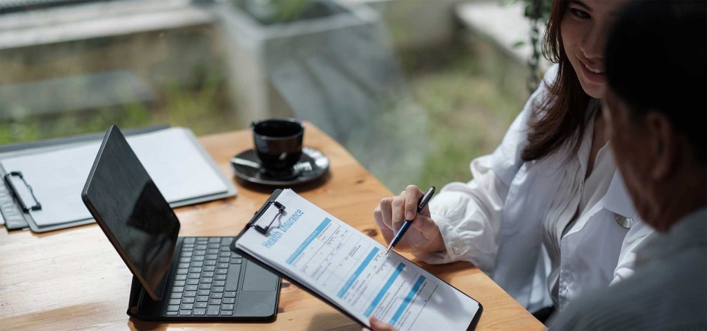 A woman with a clipboard completes a form with a man