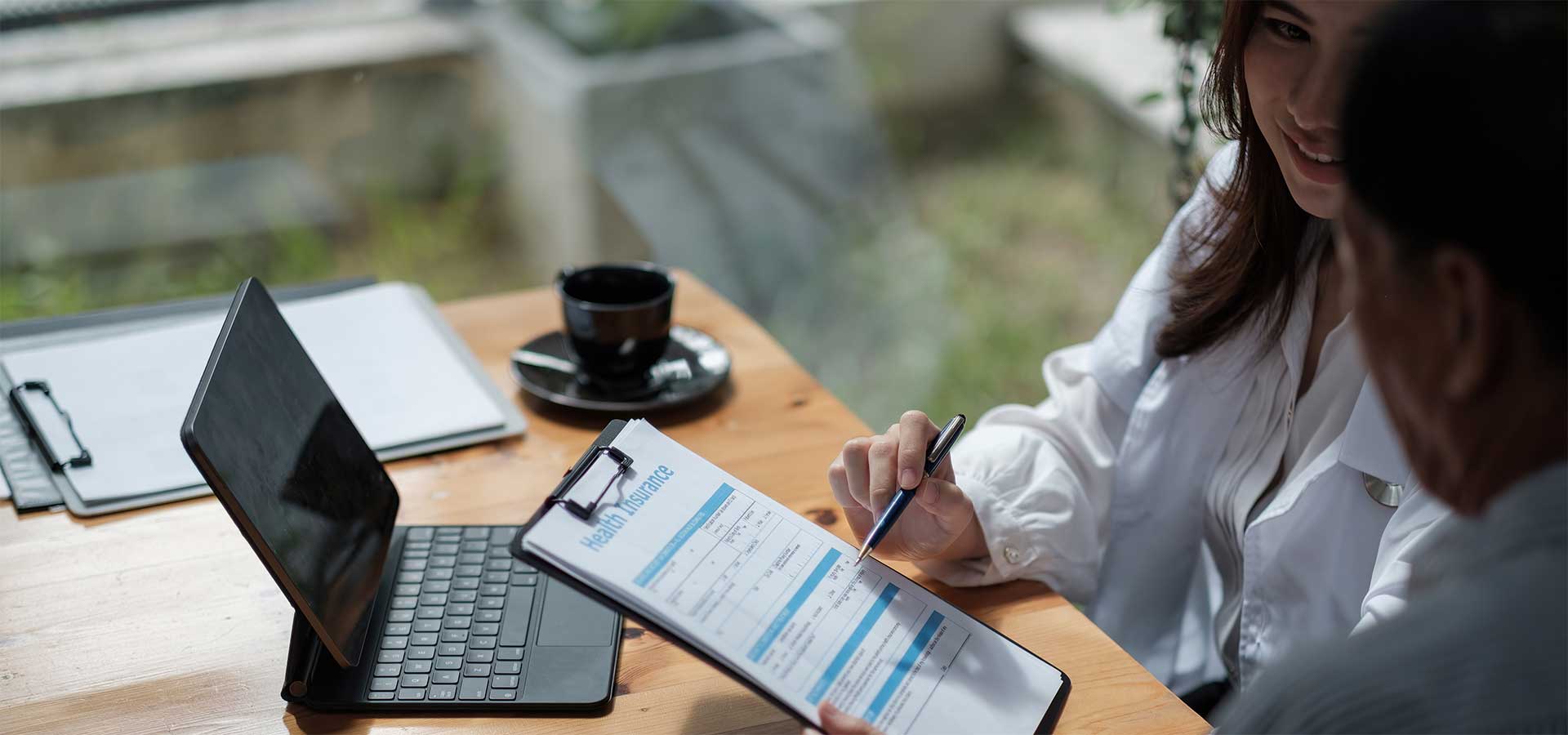 A woman with a clipboard completes a form with a man